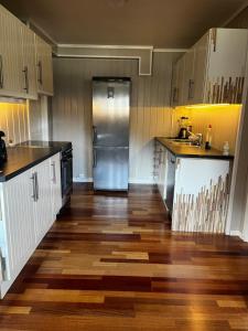 a kitchen with wooden floors and a stainless steel refrigerator at Leilighet for korttidsleie in Otta +8 photos