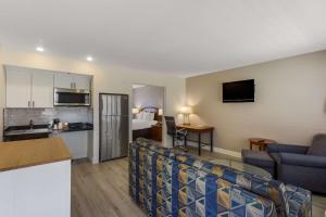 a living room with a couch and a room with a bed at SureStay Plus Hotel by Best Western Tempe University in Tempe