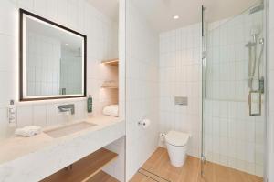 a bathroom with a shower and a sink and a toilet at Hilton Garden Inn Busselton in Busselton