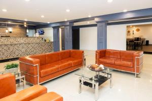 a lobby with two leather couches and a table at Bhagat Hotels Stone Mountain Atlanta BW Signature Collection in Tucker