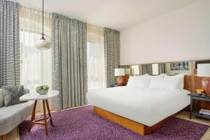 1 dormitorio con 1 cama blanca grande y 1 sofá en The Bankers Alley Hotel Nashville, Tapestry Collection by Hilton, en Nashville