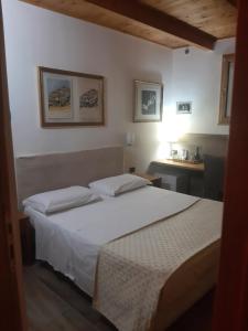 a bedroom with a white bed and a sink at Villa Mola Bed And Breakfast in Corbara
