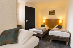 a hotel room with two beds and a couch at initial by balladins Saint-Quentin / Gauchy in Gauchy