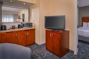 シャーロットにあるSonesta Select Charlotte University Research Parkのテレビとベッドが備わるホテルルームです。