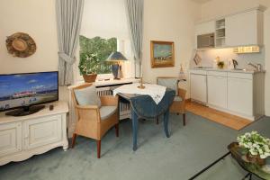 ein Wohnzimmer mit Tisch und Stühlen und einem Fernseher in der Unterkunft Villa Fortuna mit Meerblick in Bansin in Bansin + 2 Fotos