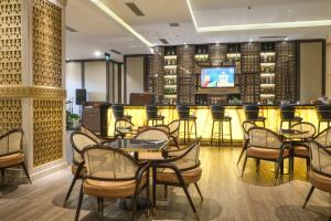 een restaurant met tafels en stoelen en een bar bij Hotel Chanti Managed by TENTREM Hotel Management Indonesia in Semarang