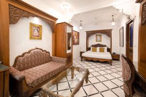 ein Schlafzimmer mit einem Bett und einem Sofa in einem Zimmer in der Unterkunft Hotel Pearl Palace Jaipur in Jaipur