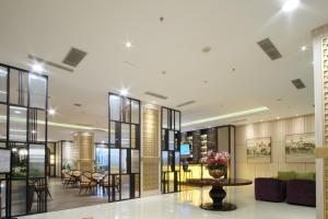 a lobby of a building with a table and chairs at Hotel Chanti Managed by TENTREM Hotel Management Indonesia in Semarang