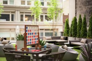 an outdoor patio with chairs and a board on a table at Embassy Suites By Hilton New York Manhattan Times Square in New York