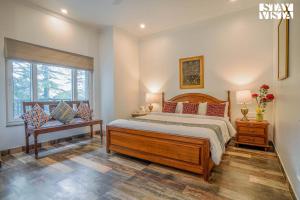 a bedroom with a large bed and a window at StayVista at Pineview @ Albert Estate in Mussoorie