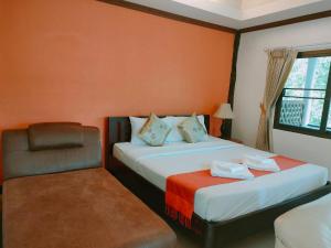 una habitación de hotel con 2 camas y una silla en เพชรมณีกาญจน์ บีช รีสอร์ท en Ban Plai Huai Kaeng Riang