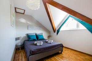 um quarto com uma cama com almofadas azuis em Kaz Combava em Étang-Salé