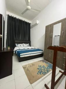 1 dormitorio con cama, mesa y espejo en Homestay MamaTwinz, musslimstay, Parit Buntar en Parit Buntar