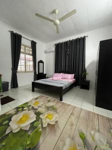 ein Schlafzimmer mit einem Bett mit Blumen auf dem Boden in der Unterkunft Homestay MamaTwinz, musslimstay, Parit Buntar in Parit Buntar