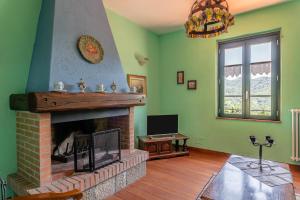 a living room with a fireplace and a television at Rifugio Arcobaleno in Popiglio