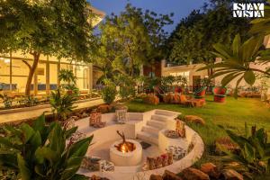 uma fogueira no meio de um quintal em StayVista's Indraj Manor - Roman-Inspired Villa with Posh Interiors, Mesmerizing Garden & Outdoor Fireplace em Nova Deli