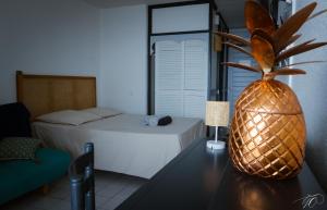 una camera con un letto e un ananas su un tavolo di GAP a Le Diamant