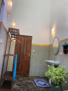 a bathroom with a sink and a ladder and a mirror at Amba Kola Udawalawa in Udawalawe