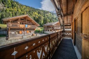 a balcony of a log cabin with a view of a river at Chalet La Grangerie in Montriond