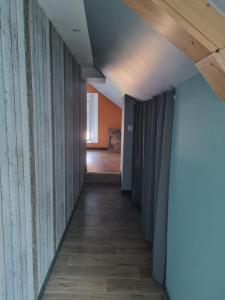 einen Flur mit Holzvertäfelung und einer Decke in der Unterkunft Chambre oiseaux in Larchamp