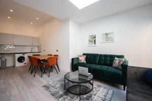 a living room with a green couch and a table at Richmond by Capital in London