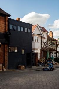 a black house with a brick street and buildings at Richmond by Capital in London