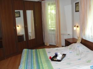 Un dormitorio con una cama con una bandeja de comida. en Villa Persenk, en Lyaskovo
