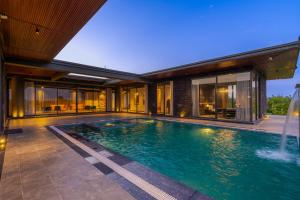 uma piscina no quintal de uma casa em StayVista's Anantam - Villa with Massive Outdoor Pool with Deck & Sprawling Lawn em Nova Deli