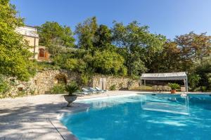 een zwembad met stoelen en een stenen muur bij Villa Magnolia in Arcugnano