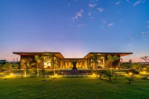 um grande edifício com luzes à frente em StayVista's Anantam - Villa with Massive Outdoor Pool with Deck & Sprawling Lawn em Nova Deli