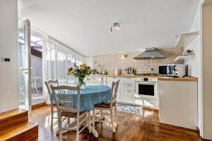 uma cozinha com mesa e cadeiras e uma cozinha com electrodomésticos brancos em Villa Magnolia em Arcugnano