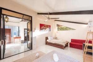 Habitación con cama y sofá rojo en Casa Bianca Siargao, en General Luna