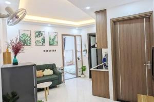 a living room with a green couch and a kitchen at Cozy apartment w/ 2 private BR & free bike parking in Hanoi