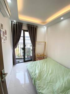 a bedroom with a green bed and a window at Cozy apartment w/ 2 private BR & free bike parking in Hanoi