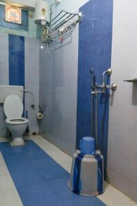 a blue bathroom with a toilet and a shower at Sea Pearl Homestay in Port Blair