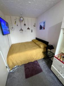 a bedroom with a bed with a yellow bedspread at Private room in Amley