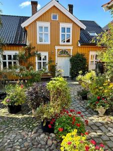 una casa amarilla con flores delante en Tollgaarden Gjestegaard, en Larvik