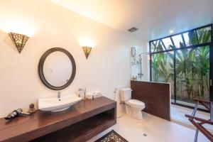 a bathroom with a sink and a mirror at Casa Bianca Siargao in General Luna