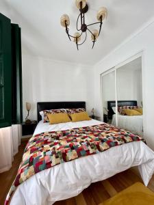 - une chambre avec un grand lit et un lustre dans l'établissement Mouradia Moura, à Moura