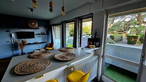 une chambre avec une table, des chaises et une fenêtre dans l'établissement Le Kalloé, à Thonon-les-Bains
