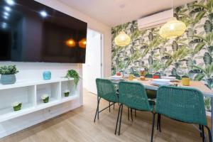 een eetkamer met een tafel en groene stoelen bij Bonito apartamento a pocos minutos del centro CLAV- in Málaga