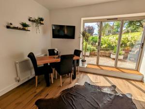 a dining room with a table and chairs and a window at The Snug at Cefn Tilla Court in Usk