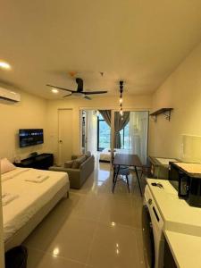 un soggiorno con letto e ventilatore a soffitto di BC@The Shore KK City View亚比城市景观 a Kota Kinabalu