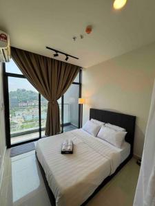 una camera da letto con un grande letto con una grande finestra di BC@The Shore KK City View亚比城市景观 a Kota Kinabalu