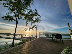 a wooden deck with a table and chairs overlooking the water at THE SHORE KK CITY VIEW S15 By BC 亚比城市景观 in Kota Kinabalu