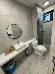a bathroom with a sink and a toilet and a mirror at THE SHORE KK CITY VIEW S15 By BC 亚比城市景观 in Kota Kinabalu