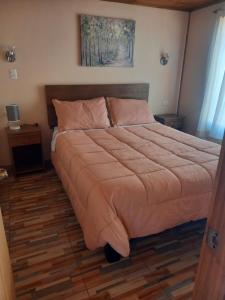 een groot bed in een slaapkamer met een houten vloer bij Cabañas Reina Margarita in Santa Cruz