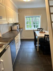 a kitchen and dining room with a table and chairs at Tollgaarden Gjestegaard in Larvik