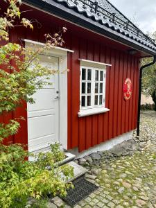 a red house with a white door and a window at Tollgaarden Gjestegaard in Larvik