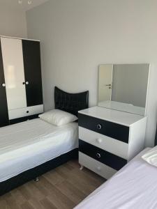 1 Schlafzimmer mit 2 Betten und einer Kommode mit einem Spiegel in der Unterkunft İSTANBUL, KOZA PARK in Bahcesehir